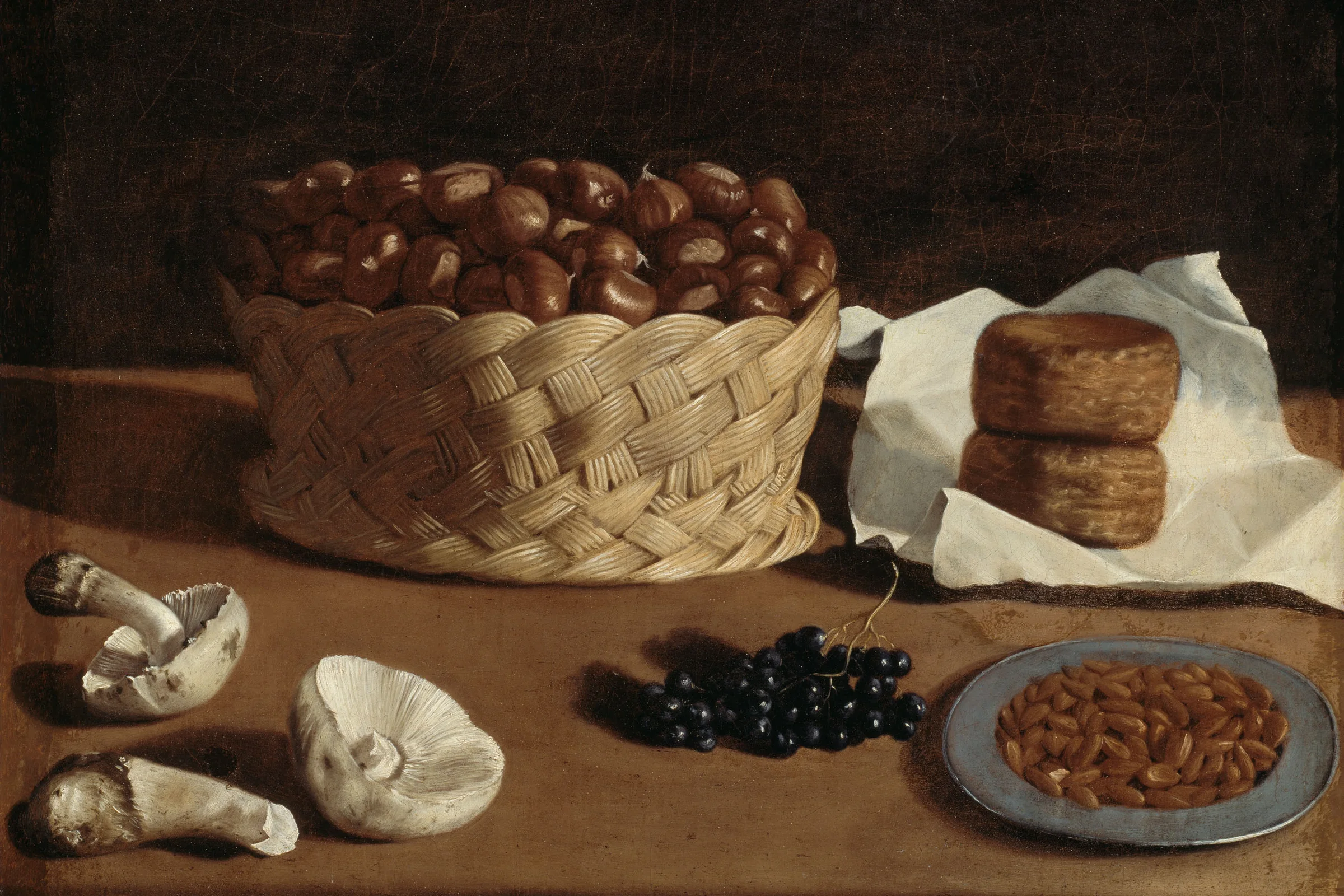 Kitchen Still Life, an Italian oil painting from about 1640 attributed to Paolo Antonio Barbieri: chestnuts in a woven basket, cheese, mushrooms, grapes and almonds