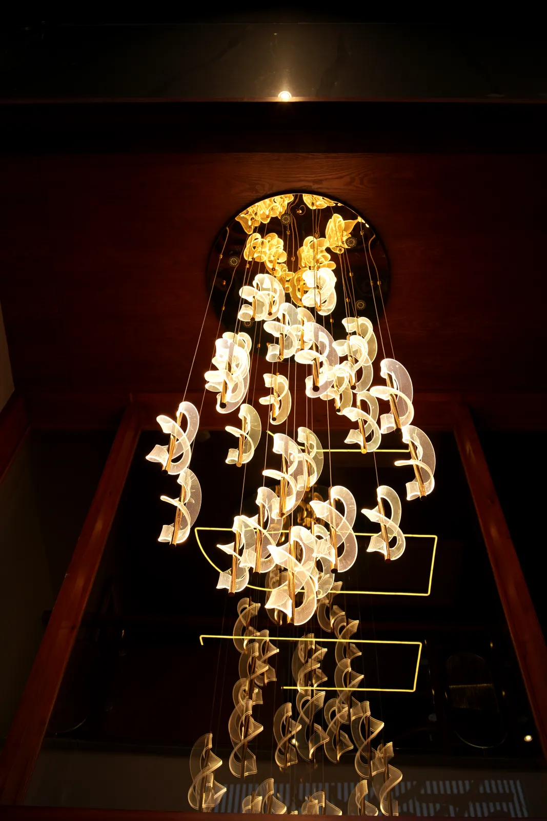 Sculptural chandelier cascading down the stairwell