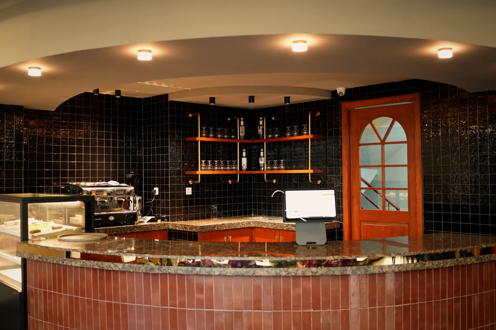 Espresso bar with black tiles and copper shelving